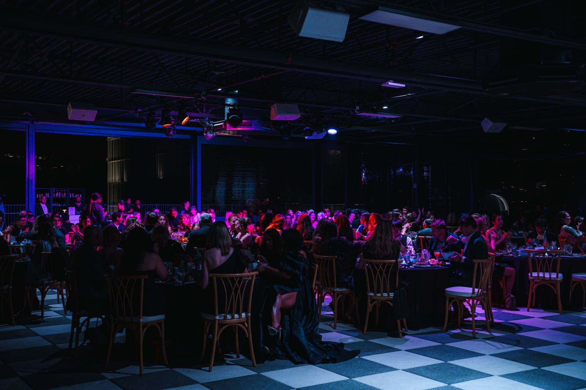 A full room seated for a gala dinner under warm lights